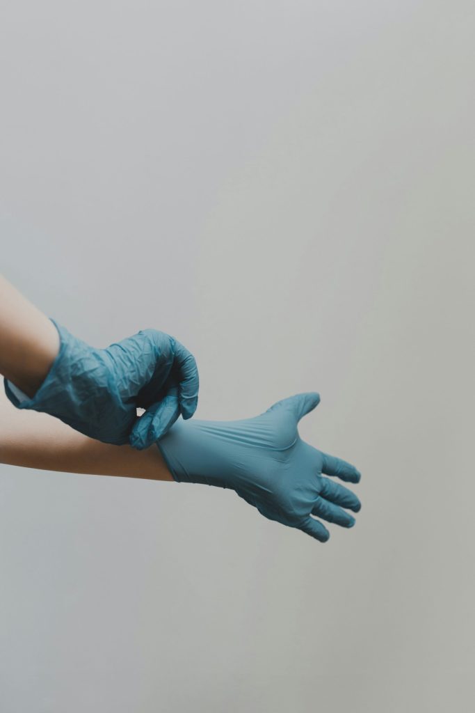 Person putting on blue protective gloves