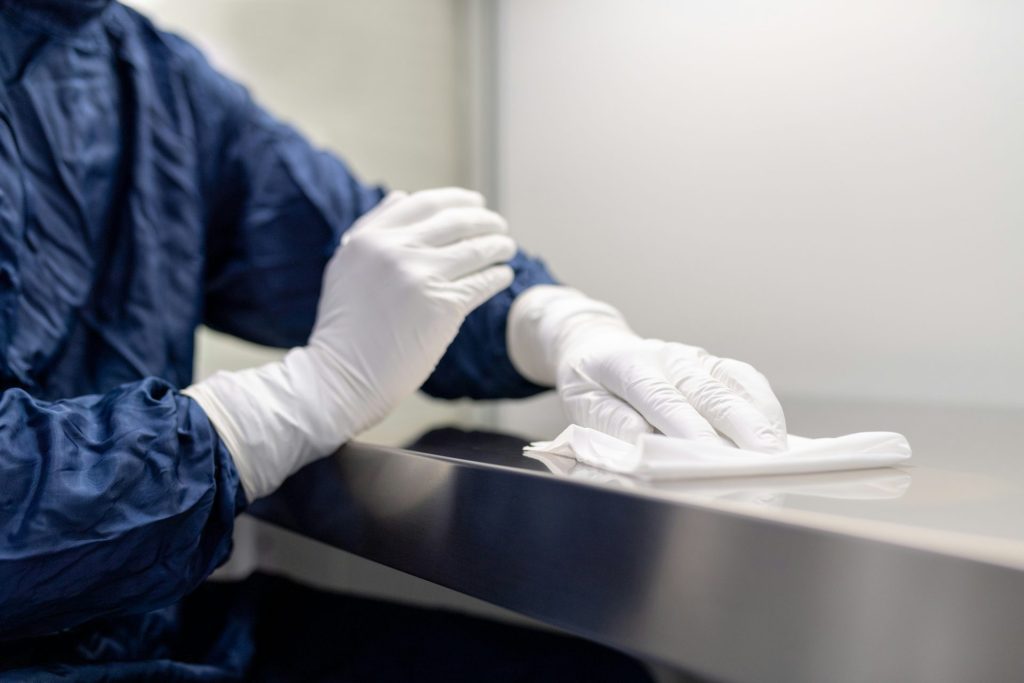 Person wiping a surface in cleanroom